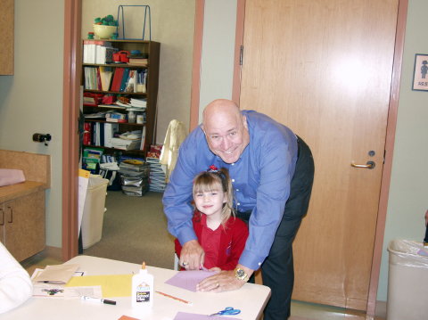 Grandpa helps Korie cut out hands